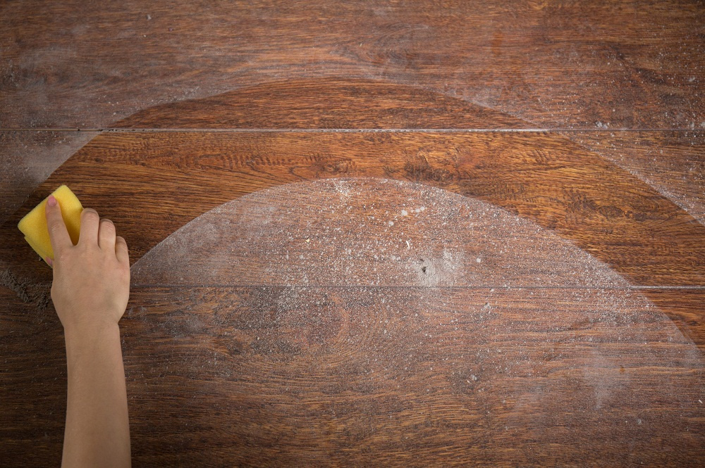 Man wiping dust off of table