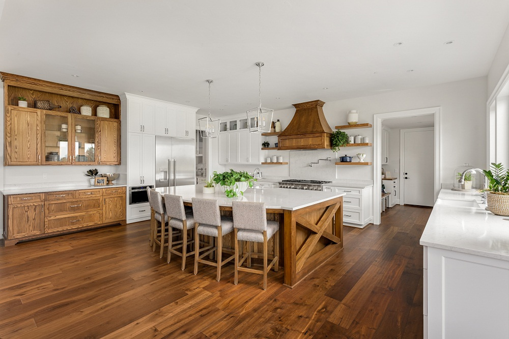 Newly installed wooden floor in kitchen with island chairs at island
