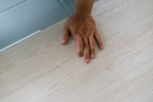 closeup of professional laying luxury vinyl flooring in home