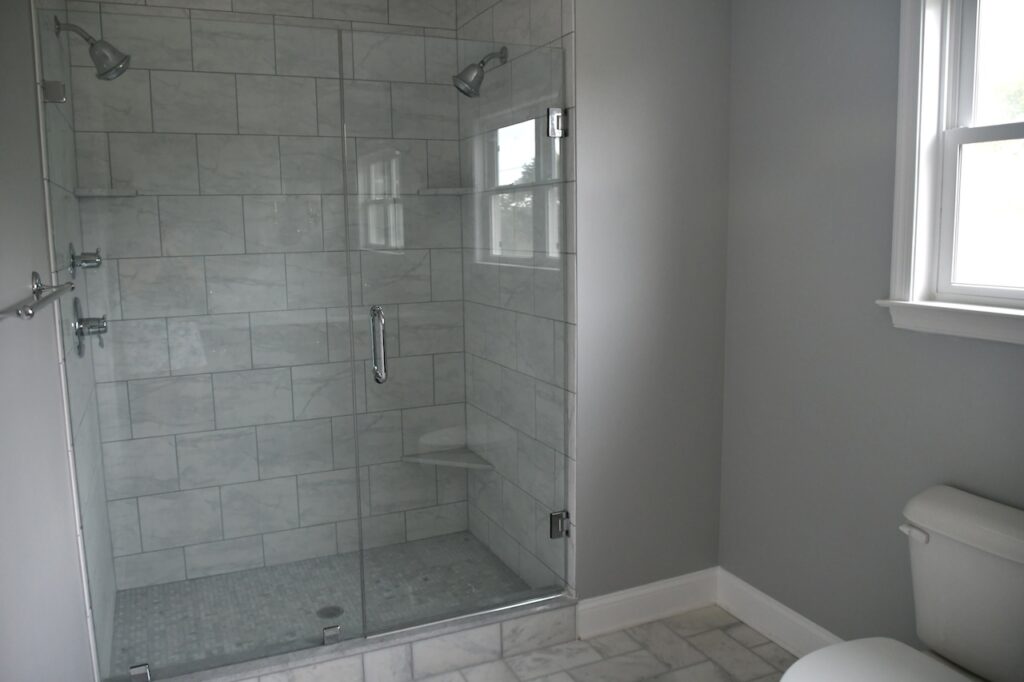 bathroom with new gray shower tile and updated fixtures