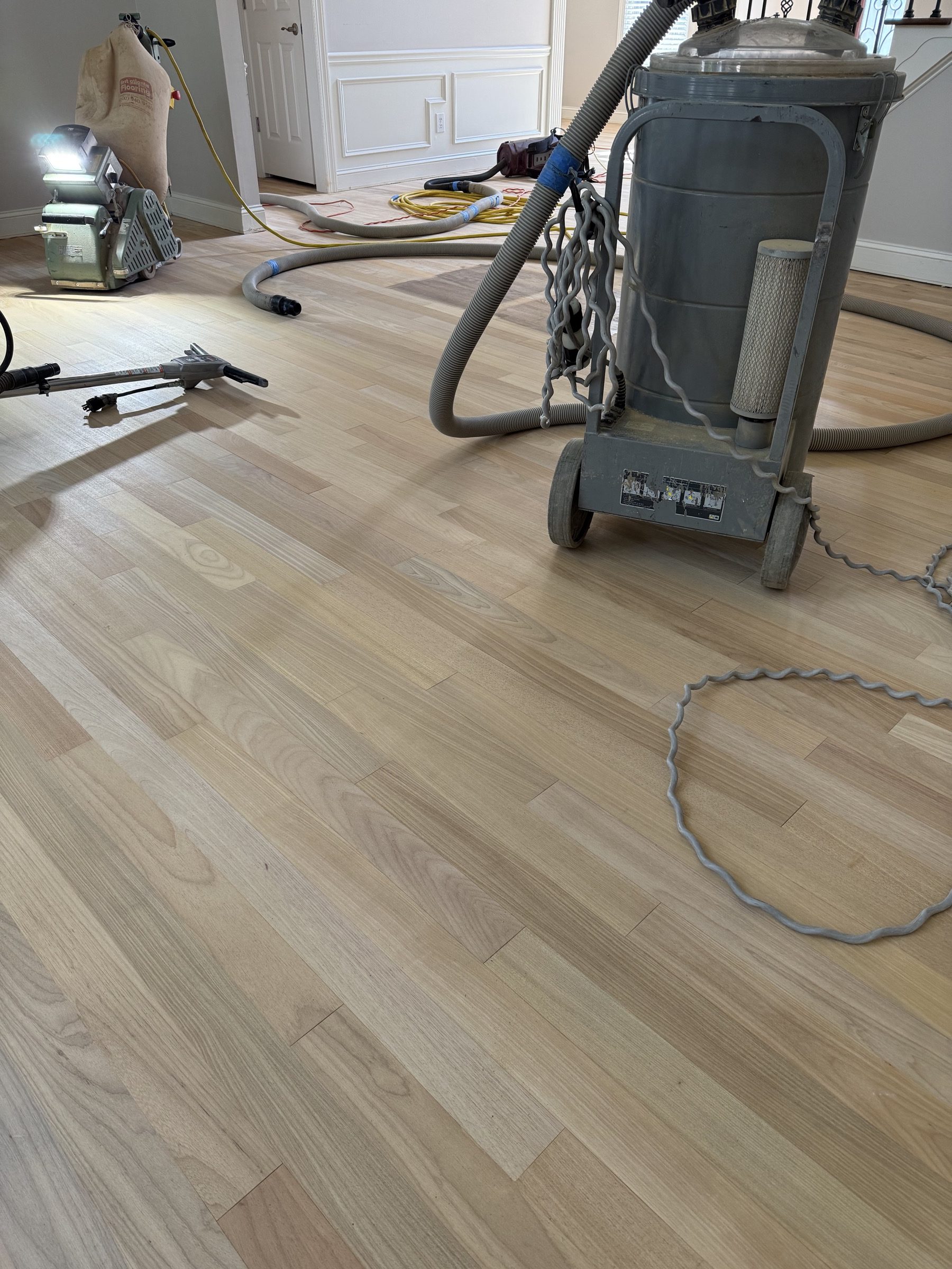Dust-extraction vacuum and sanding equipment on a freshly sanded hardwood floor in a Johns Creek, GA home, by Atlanta Floor One