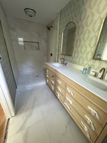 Finished Sandy Springs GA bathroom remodel with marble-look porcelain tile floor, tiled walk-in shower and herringbone niche by Atlanta Floor One