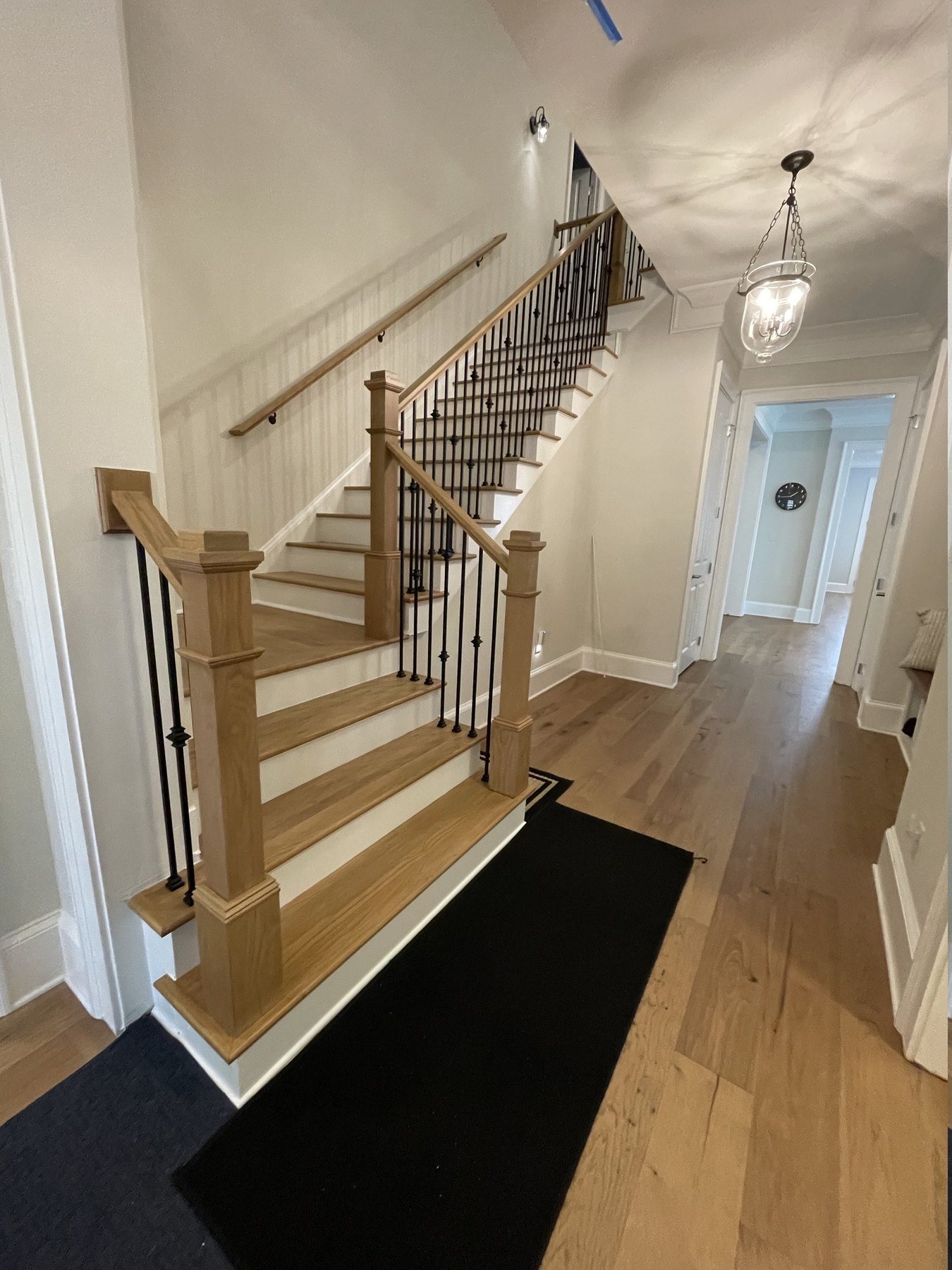 Alpharetta, GA staircase after remodeling — white oak treads, painted risers, square newel posts and iron balusters