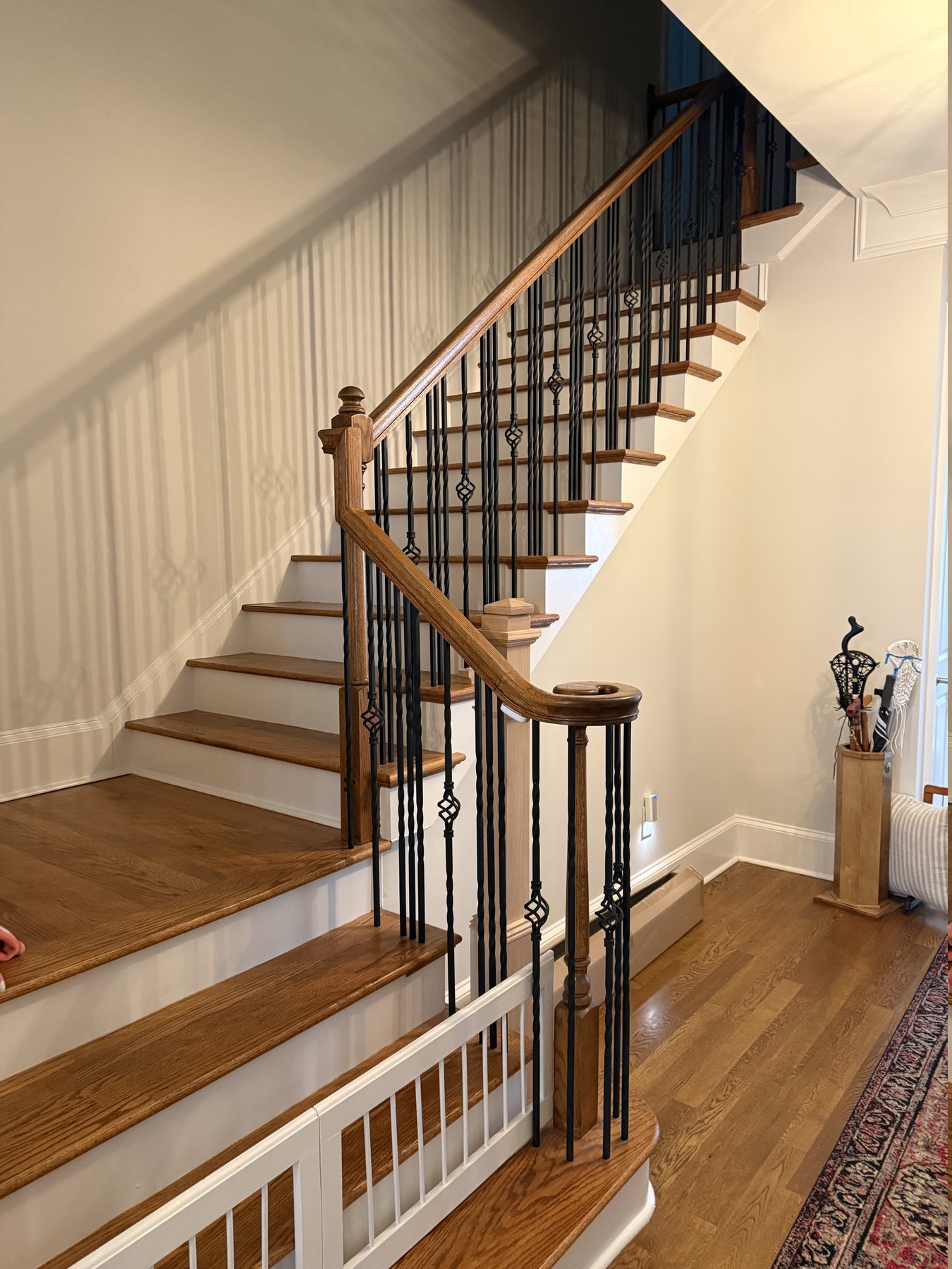 Alpharetta, GA staircase before remodeling — dark-stained oak treads, matching handrail and turned newel posts
