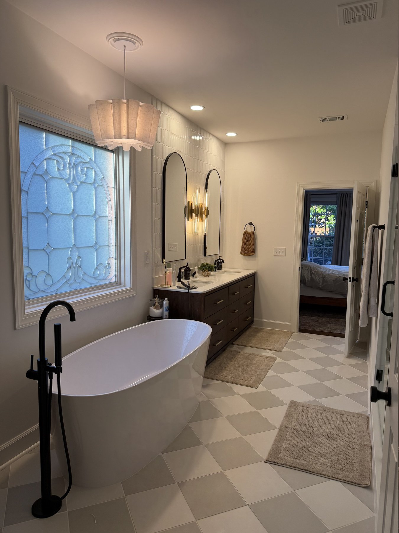 Finished master bathroom remodel in a Roswell, GA home with a two-tone checkerboard tile floor, freestanding tub and matte black fixtures, by Atlanta Floor One