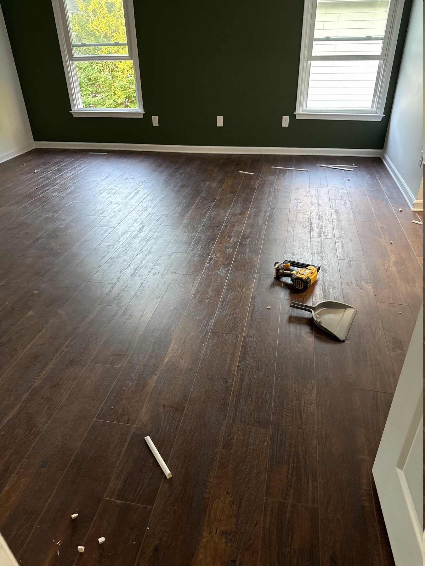 Newly installed dark distressed plank flooring with tools still on the floor before cleanup, flooring installation by Atlanta Floor One